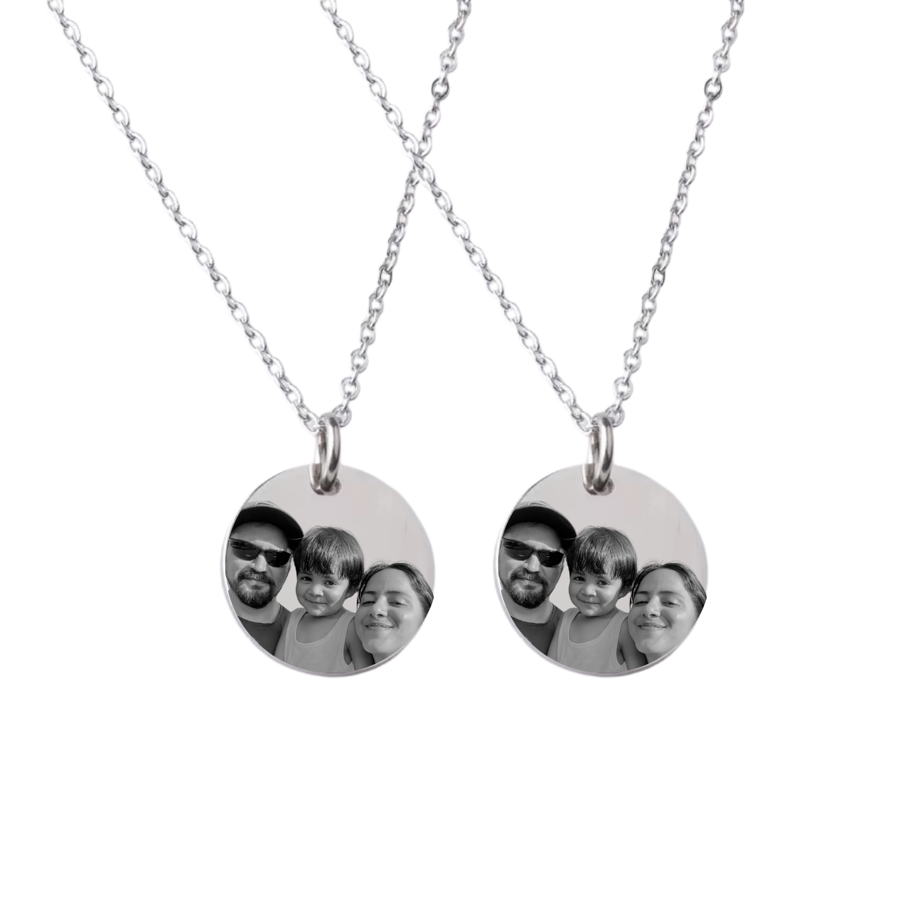 Two silver necklaces with circular pendants showing family photos on a white background