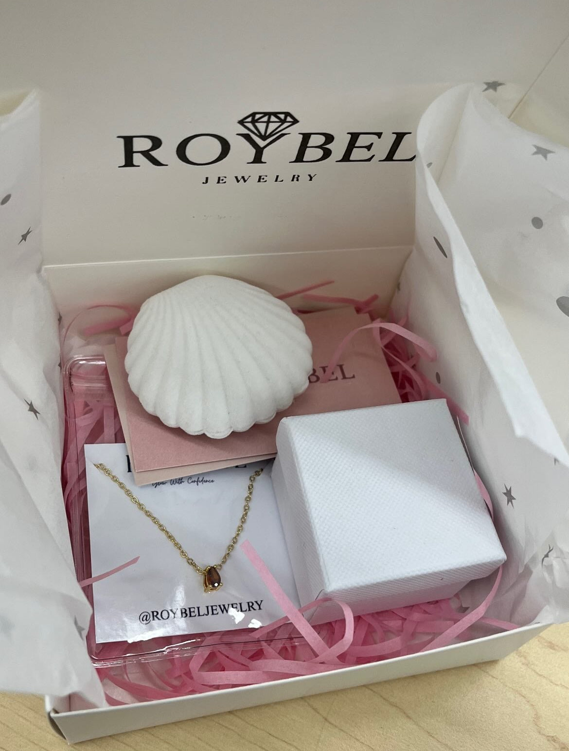 Jewelry set in a 'ROYBEL' branded box on a wooden surface