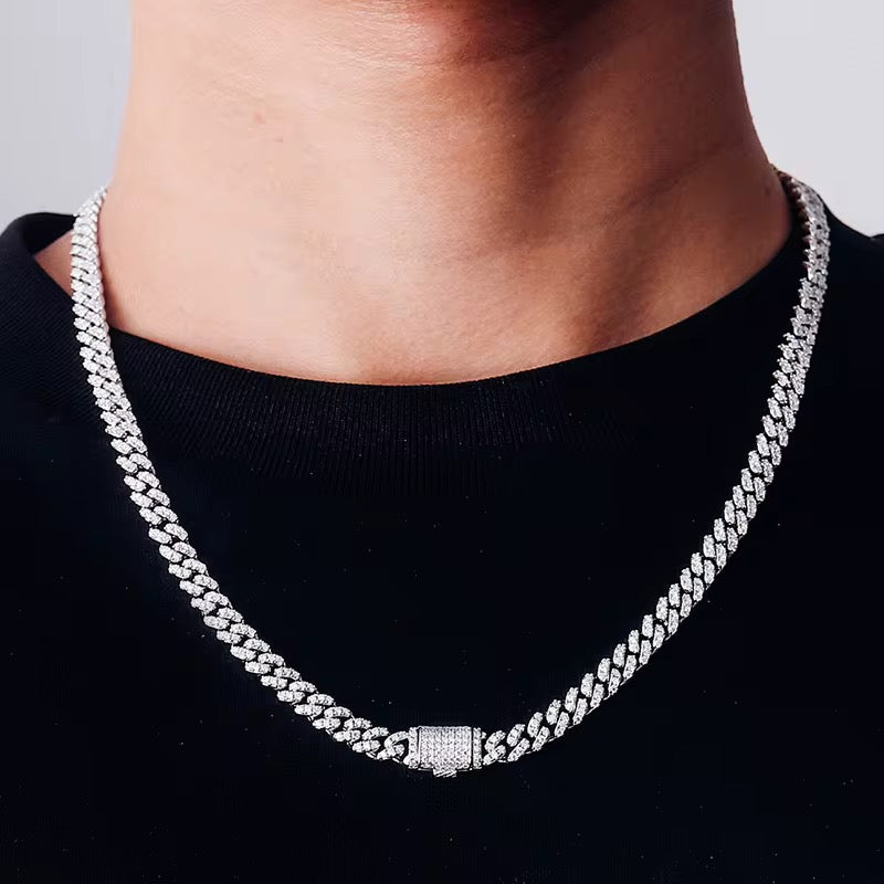 Silver chain necklace worn by a person on a black background