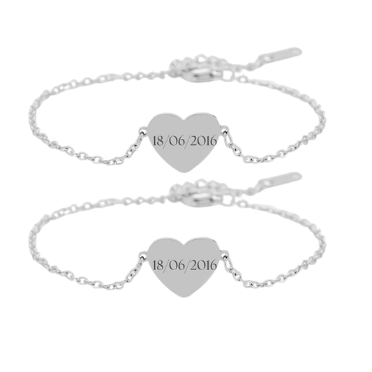 Silver bracelet with heart-shaped engraved charms on a white background