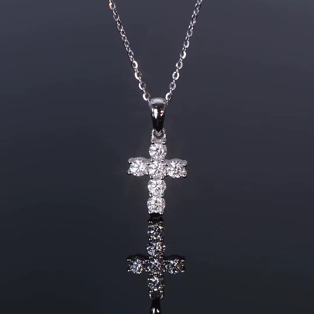 Silver cross pendant necklace on a black background