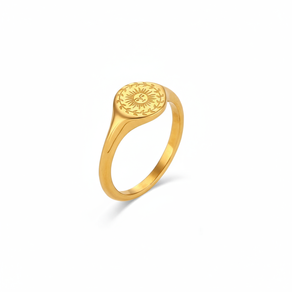 Gold ring with sun design on a white background
