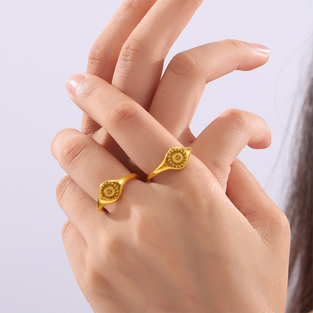 Gold ring on a finger against a light background
