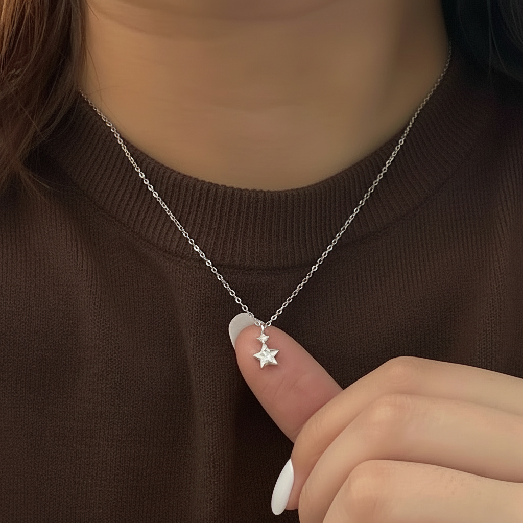 Silver necklace with a star pendant worn by a person against a brown background