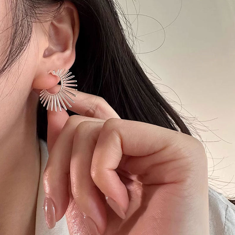 Close-up of a person wearing a silver hoop earring with a blurred background